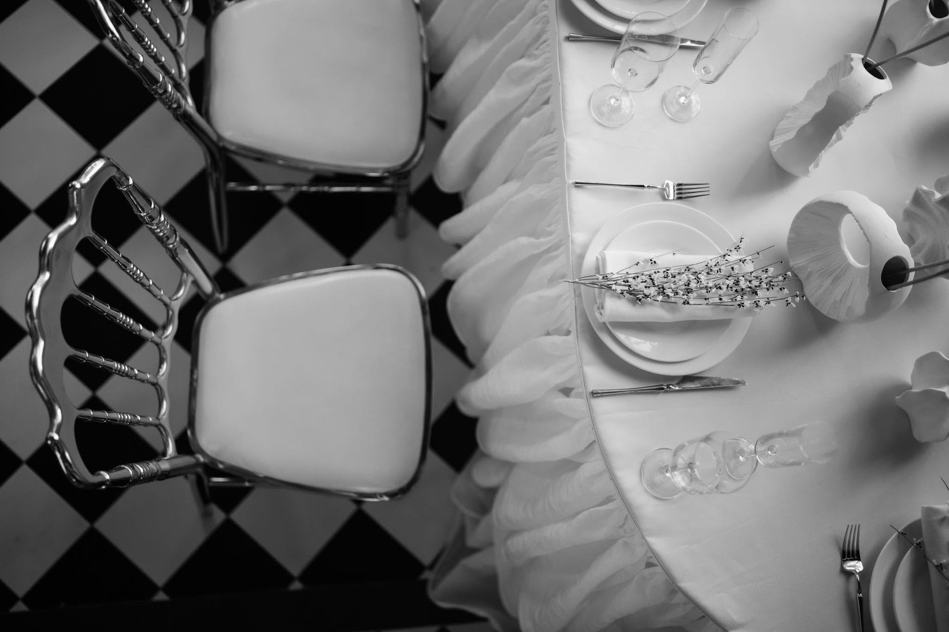 Close-up of an elegant place setting on a black and white checkered floor